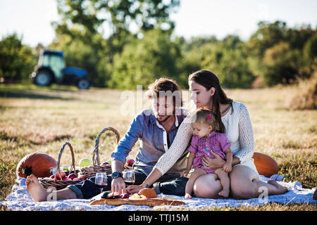 Familie Obst essen bei Picknick an einem sonnigen Tag Stockfoto