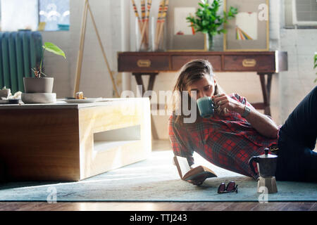 Man trinkt Kaffee beim Lesen Buch zu Hause Stockfoto