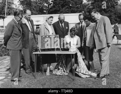 Nähen in den 1960er Jahren. Die Nähmaschine ist solarbetrieben und lenkt die Aufmerksamkeit, wenn es demonstrieren. Die Solarzellen sind auf dem Tisch neben der Maschine. Schweden 1960 Stockfoto