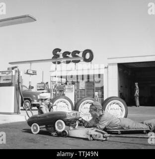 Service Station der 50er Jahre. Ein Junge in seinem Pedal Car hat sie an der Esso Tankstelle gewartet. Ein Service der Mensch hat das kleine Auto angehoben und der Wartung. Schweden 1958. Kristoffersson ref DC 100-10 Stockfoto