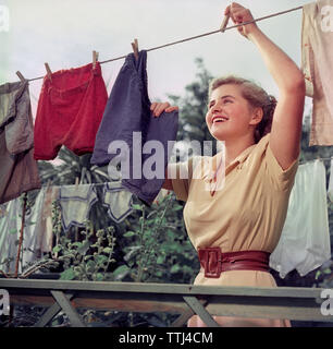 Die Wäsche in den 1950er Jahren. Eine junge Frau wird Aufhängen der nassen und saubere Wäsche zu trocknen. Schweden 1950 s ref BV 92-10 EG 232343 Stockfoto