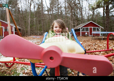 Portrait der Junge sitzt im Modellflugzeug im Park Stockfoto