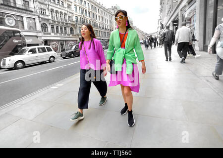 London, England, UK. Zwei farbenfroh gekleideten asiatischen Frauen in der Regent Street (Selektive Farbe) Stockfoto