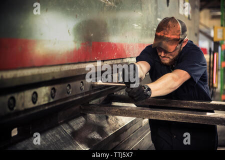 Arbeiter mit T-Schlüssel in der Metallindustrie Stockfoto