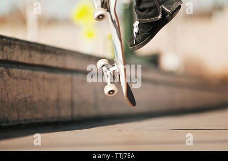 Oberfläche des Menschen Durchführung Stunt mit Skateboard Stockfoto