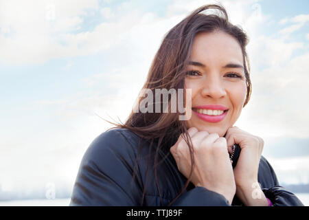 Portrait von Frau mit Händen Kinn gegen Sky Stockfoto