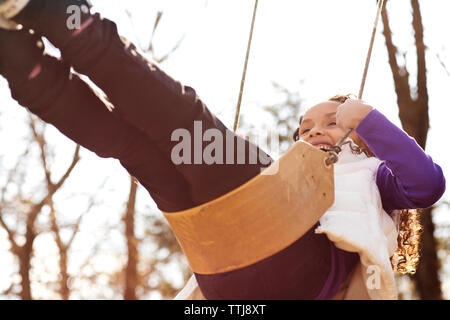 Low Angle View der glücklichen Mädchen schwingen im Park Stockfoto