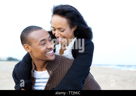 Frau auf der Suche nach Mann huckepack beim Gehen Stockfoto