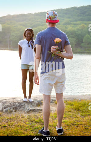 Rückansicht des Menschen verstecken sich hinter Zurück zur Freundin vorschlagen Stockfoto