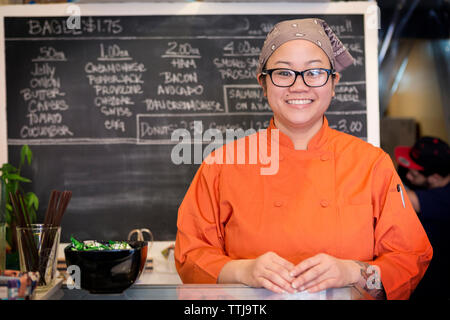Portrait von lächelnden Frau, die bei Store Stockfoto