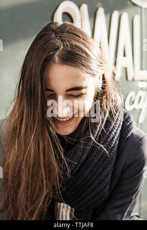 Frau lacht beim Stehen außerhalb Cafe Stockfoto