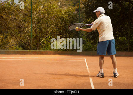 Ansicht der Rückseite des Mann spielt Tennis am Hof Stockfoto