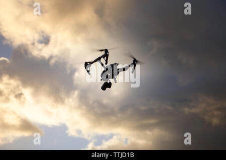 Low Angle View Der quadcopter gegen bewölkter Himmel fliegen Stockfoto