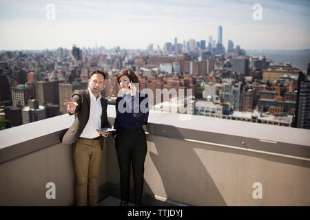 Geschäftsleute diskutieren während sie auf der Terrasse stehen Stockfoto