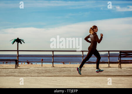 Schwimmer Jogging auf Pier am Strand Stockfoto