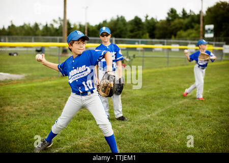 Jungen spielen Baseball auf Feld Stockfoto