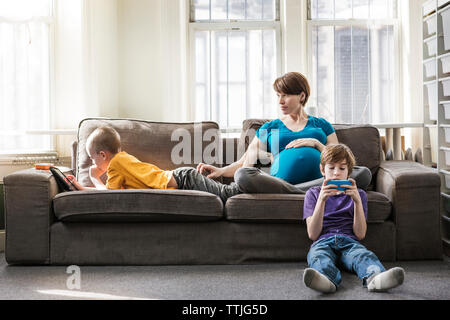 Schwangere Frau mit Kindern zu Hause Stockfoto