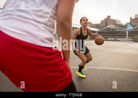 Basketball Spieler spielen im Hof Stockfoto