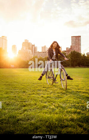 Verspielte Frau Radfahren im Central Park Stockfoto