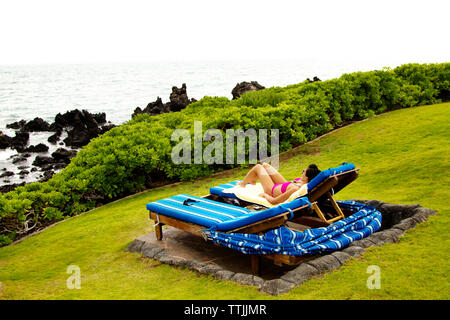 Frau entspannend auf Lounge Chair im Tourist Resort Stockfoto