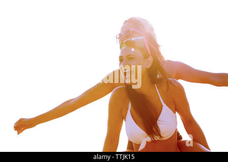Low Angle View von Frau huckepack Freund gegen den klaren Himmel Stockfoto