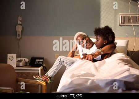 Mädchen mit grossvater am Bett im Krankenhaus Stockfoto