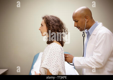Seitenansicht der Arzt untersucht den Patienten zurück Stockfoto