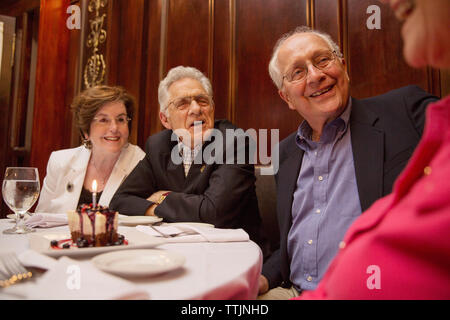 Ältere Freunde sprechen beim Sitzen im Restaurant Stockfoto