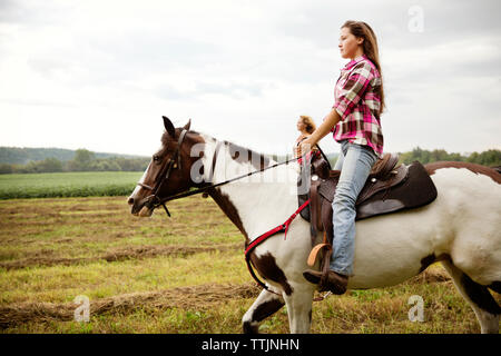 Seitenansicht des Cowgirls reiten auf Pferd Stockfoto