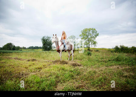 Frau weg, beim Sitzen auf dem Pferd gegen Sky Stockfoto