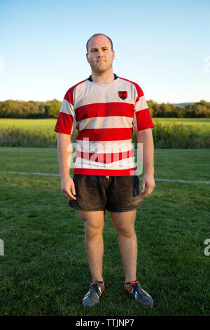 Volle Länge Portrait von Rugby Player stehen auf Wiese Stockfoto