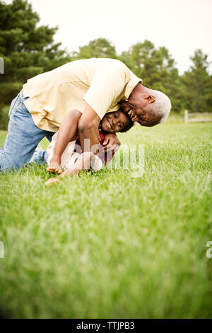 Großvater mit Enkel sitzen auf der Wiese im Hinterhof Stockfoto