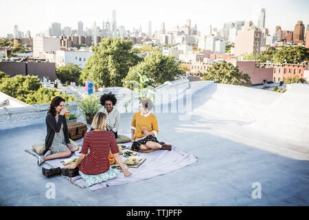 Gerne Freunde Essen genießen auf Gebäude Terrasse Stockfoto