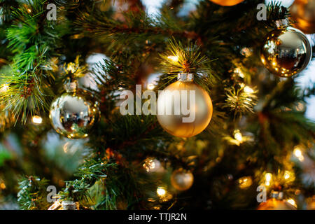 Nahaufnahme der Verzierungen und die Lichter am Weihnachtsbaum Stockfoto