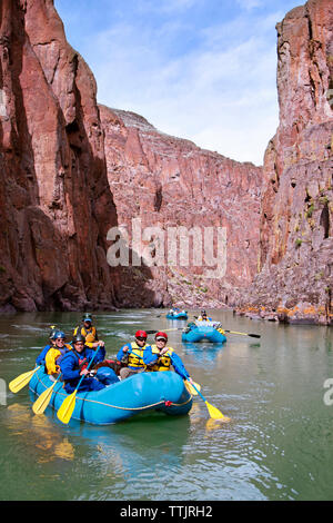 Freunde River Rafting im Fluss inmitten von Bergen Stockfoto