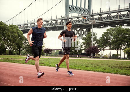 Freunde, die auf Sport track gegen die Triborough Bridge Stockfoto
