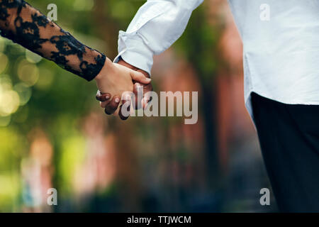 Image der jungen Paar Hand in Hand auf der Straße 7/8 Stockfoto