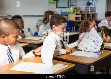 Studenten Bücher während der Lektion im Klassenzimmer auf der Suche Stockfoto