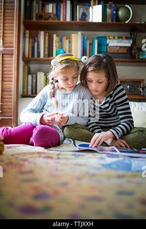 Mädchen studieren, während auf dem Boden zu Hause sitzen Stockfoto