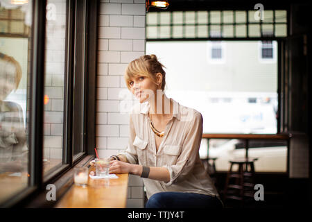Frau weg, beim Sitzen auf Hocker in bar Stockfoto