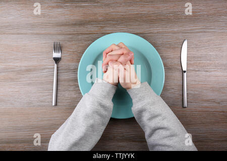 Mann hält die Hände über leeren Teller. Hunger Konzept Stockfoto