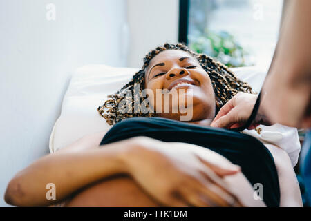 7/8 Hand der Arzt die schwangere Frau liegend auf Bett im Krankenhaus Stockfoto