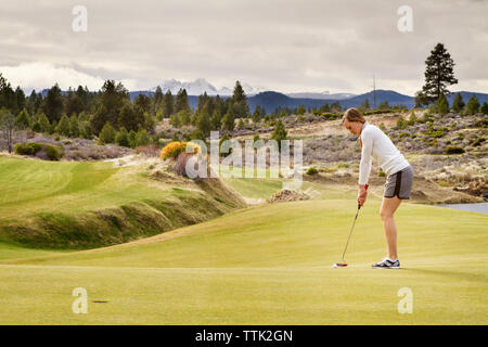 Seitenansicht der Frau spielen Golf auf dem Feld Stockfoto