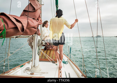 Freunde sprechen bei Reisen im Segelboot Stockfoto