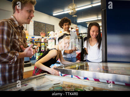 Freunde spielen bei Flipper im Arcade Stockfoto