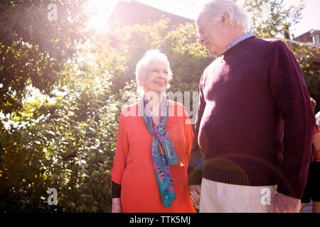 Senior Paar Hände halten beim Stehen im Park an einem sonnigen Tag Stockfoto