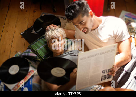 Ansicht von oben der Paare auf der Suche nach Schallplatten beim liegen auf dem Boden Stockfoto