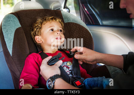 Zugeschnittenes Bild des Vaters Befestigung Sicherheitsgurt von Son Stockfoto