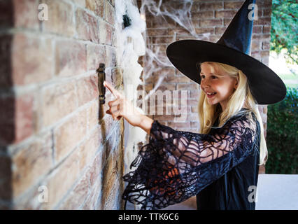 Mädchen gekleidet in Hexe Kostüme läutenden Türglocke Stockfoto