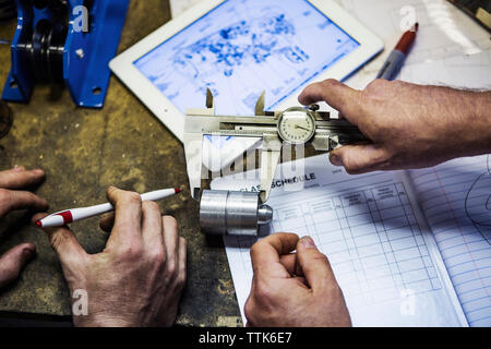 Zugeschnittenes Bild der Mechanik Metall messen mit verstellbaren Bremssattel in der Werkstatt Stockfoto